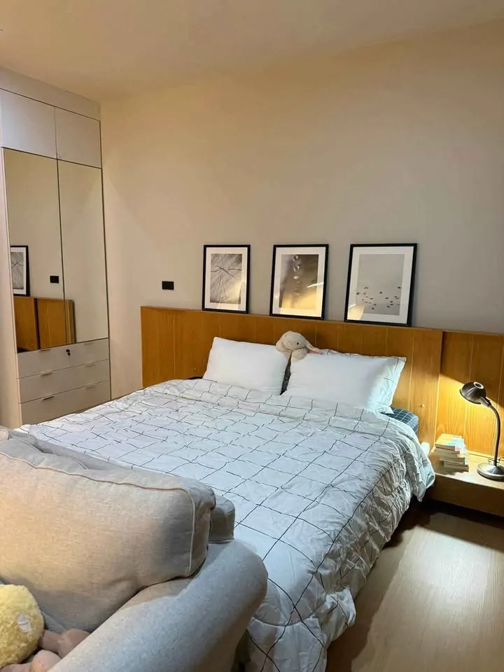 Bedroom with a large bed, wooden headboard and framed pictures on the wall, unit DA-3103248