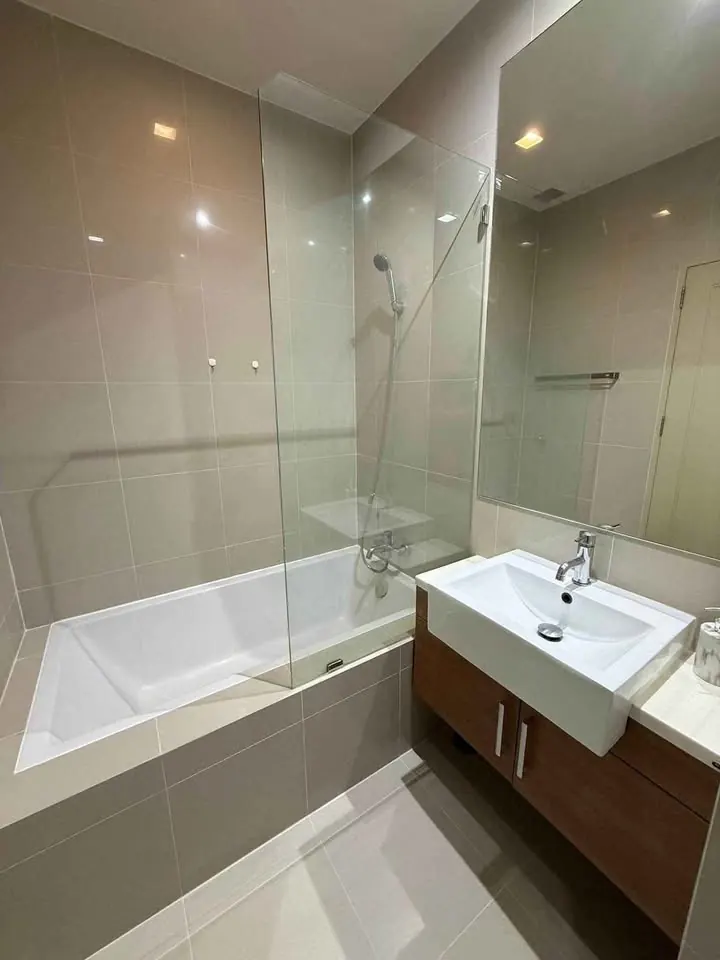Bathroom with a glass-screened bathtub and a basin on a wooden vanity, unit DA-3103248