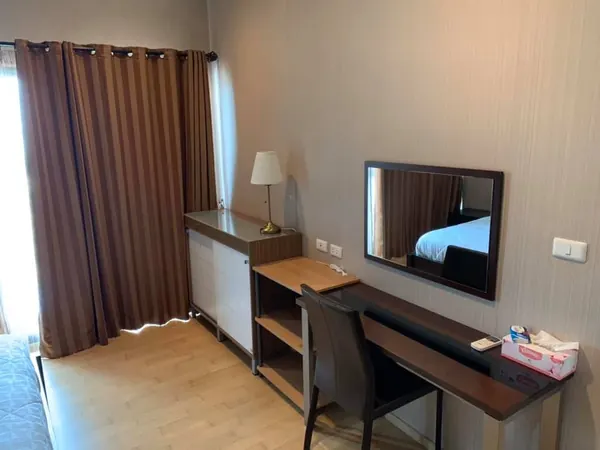 Desk with a mirror and table lamp beside a window with brown curtains, unit DA-6885