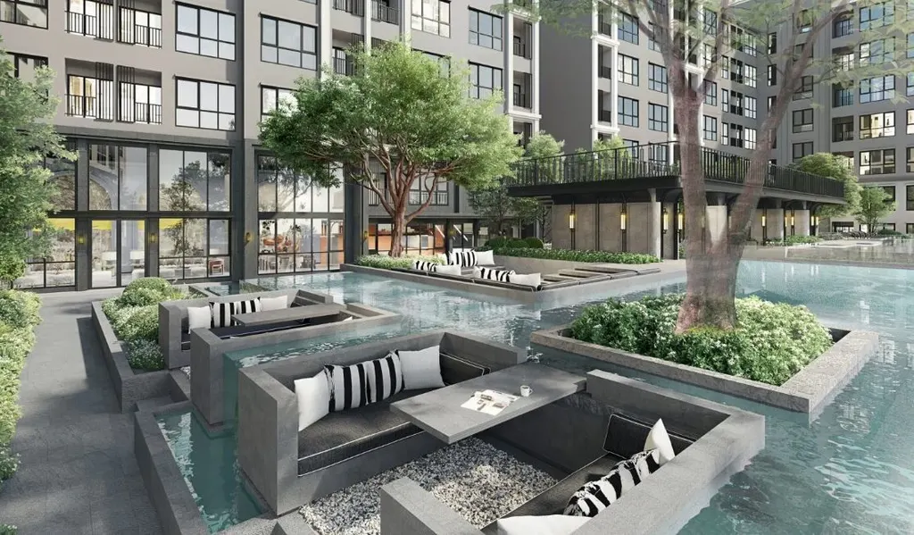Swimming pool and central garden of a Bangkok condominium in daylight, with the residential tower behind (article illustration)